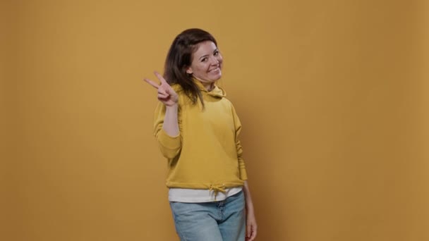 Retrato Mujer Sonriente Casual Mostrando Gesto Mano Signo Paz Estudio — Vídeo de stock