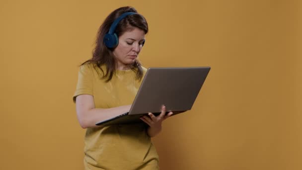 Mulher Casual Usando Fones Ouvido Sem Fio Segurando Laptop Digitando — Vídeo de Stock