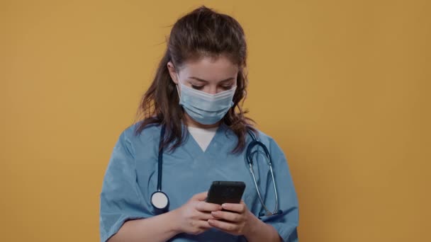 Hastane Üniformalı Cerrahi Maske Takan Elinde Akıllı Telefon Olan Kameraya — Stok video