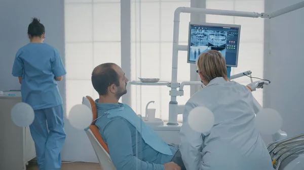 Specialista e paziente che guarda il monitor con scansione a raggi X — Foto Stock