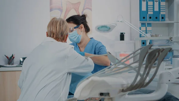Команда специалистов консультирует пациента с зубной болью — стоковое фото
