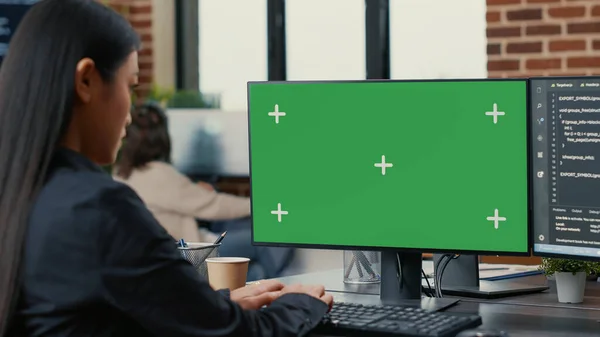 Zaměření na obrazovku počítače se zelenou obrazovkou chroma klíč mockup před asijského programátora psaní kódu — Stock fotografie