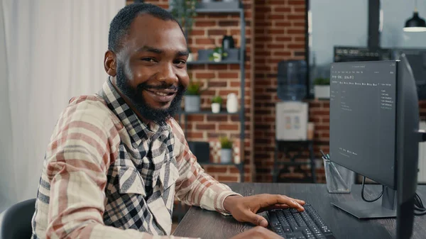 Desarrollador de software escribiendo código de programación en el teclado de la computadora girando cabeza y sonriendo —  Fotos de Stock