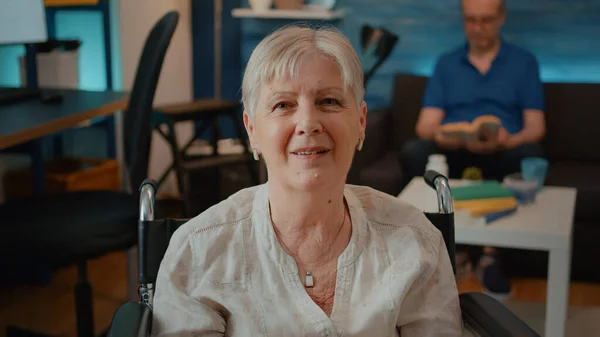 Portrait of retired woman sitting in wheelchair at home — Stock Photo, Image