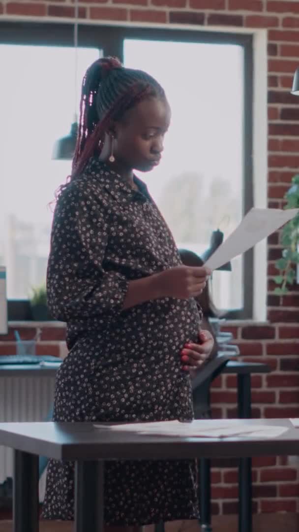Вертикальное видео: Портрет беременной женщины, работающей над бизнес-проектом — стоковое видео