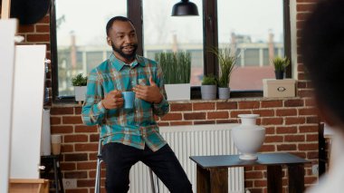 Sanat öğrencilerine vazo modeli gösteren Afrikalı Amerikalı öğretmen