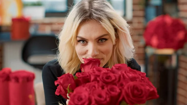 Portrait de femme séduisante amoureuse sentant la rose rouge et regardant la caméra profiter de la Saint-Valentin — Photo