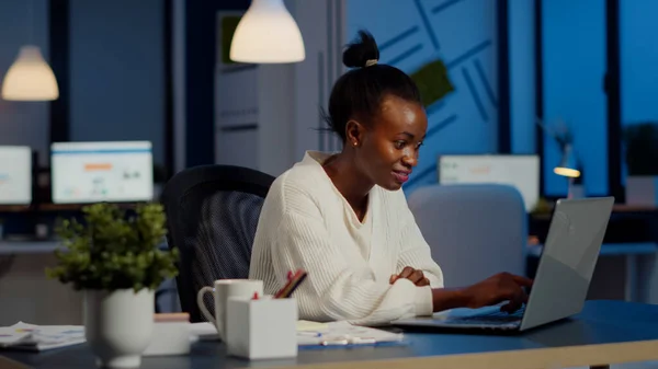 Happy african freelancer reading tasks on laptop working overtime — Stock Photo, Image