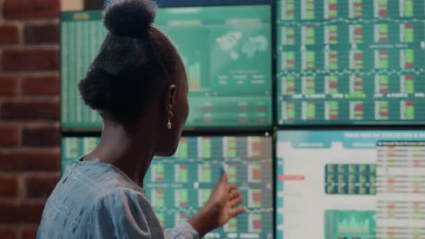 貿易市場統計で複数のモニターを分析する女性投資家 — ストック動画