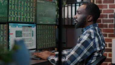 Erkek yatırımcı Forex döviz fonu satışlarını birden fazla monitörde kullanıyor