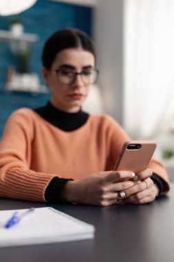 İçerik oluşturucu akıllı telefon tutuyor ve ekrandaki içeriğe bakıyor.