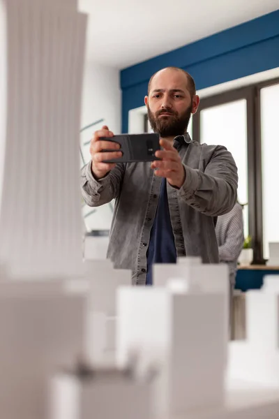 Architekt mit Smartphone, um Video der architektonischen Maquette aufzuzeichnen — Stockfoto