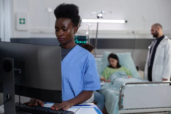 Afro-Amerikaanse verpleegkundige met behulp van personal computer voor klinische beeldvorming — Stockfoto