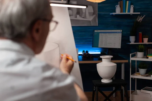 Enfoque en el modelo de jarrón blanco yeso utilizado para el estudio de la luz que dibuja el hombre de edad avanzada —  Fotos de Stock