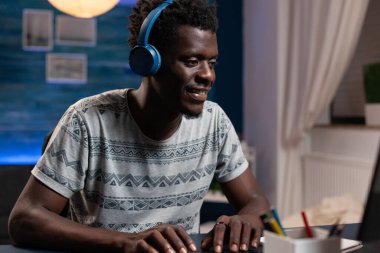İnternet kursuna katılırken kulaklık takan bir işletme öğrencisi