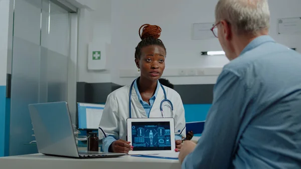 Médecin et patient âgé regardant l'écran de la tablette — Photo