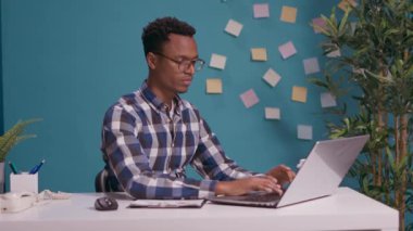 Laptop ekranının önünde mutlu bir insan başparmak hareketi gösteriyor.