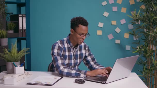 アフリカ系アメリカ人の男はノートパソコンで噂話を聞いて — ストック動画