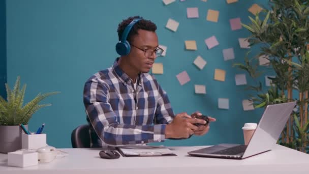 Homme afro-américain en utilisant joystick sur ordinateur portable pour jouer à des jeux vidéo — Video