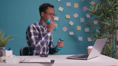 Spor işçisi kasları çalıştırmak için halterlerle ağırlık kaldırıyor.