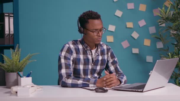 Young man talking with client on phone call at helpline call center — Stock Video