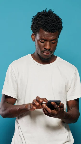 Uomo confuso utilizzando smartphone per messaggi di testo — Foto Stock