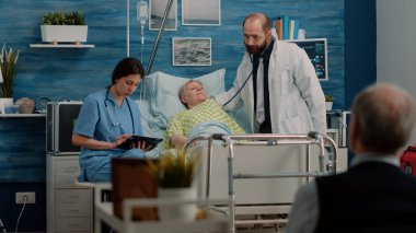 Hastalıklı yaşlı bir hasta tıbbi ekipten konsültasyon alıyor.