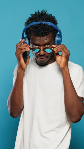 Afrykański Amerykanin za pomocą słuchawek i smartfona — Zdjęcie stockowe
