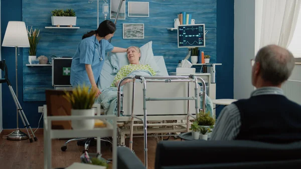 Paciente mayor en cama de hospital que recibe visita médica —  Fotos de Stock