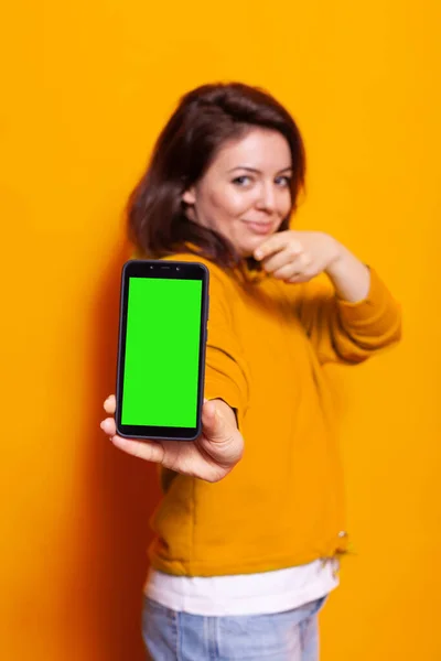 Mujer sosteniendo pantalla verde vertical en el teléfono inteligente — Foto de Stock