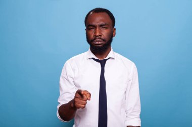 Ayakta duran işadamı, kafası karışmış bir şekilde sana doğru bakıyor.