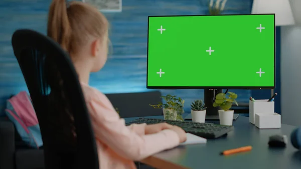 Klein kind kijkt naar horizontaal groen scherm op de computer — Stockfoto