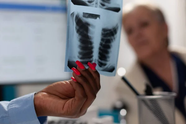 Gros plan d'un médecin tenant une radiographie pulmonaire expliquant son expertise en matière de maladie — Photo