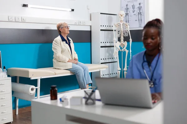 Спеціалізована медсестра, яка працює на медичному лікуванні, набираючи знання про хвороби на комп'ютері — стокове фото