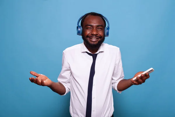 Confused man with eyes closed trying to figure out song name playing in wireless headphones — Stock Photo, Image