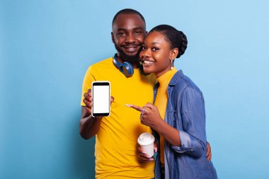 Akıllı telefondaki boş beyaz ekrana bakan gülümseyen çift