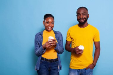 İlişkisi olan insanlar gülümsüyor ve elinde bir fincan kahve tutuyorlar.