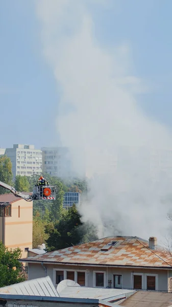 Huisbranden in de buurt van de stad en brandweerlieden helpen — Stockfoto