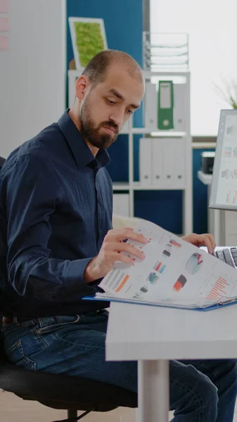 Бізнес-менеджер з використанням комп'ютера та паперів з діаграмами — стокове фото