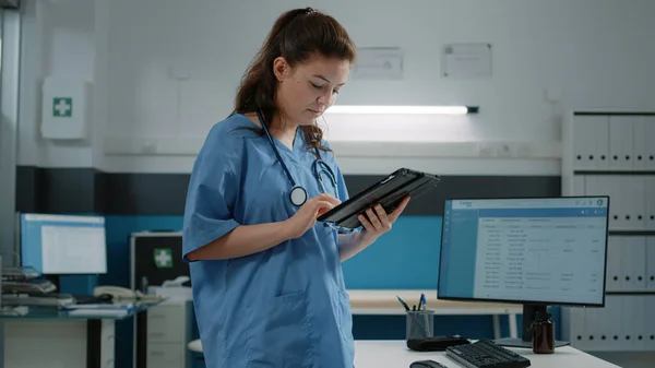 Femme travaillant comme infirmière et tenant une tablette numérique — Photo