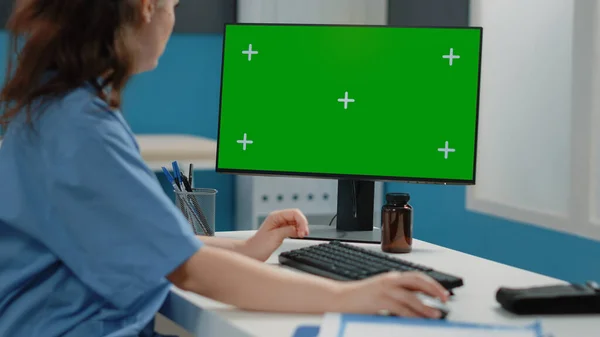Närbild av kvinna sjuksköterska tittar på horisontell grön skärm — Stockfoto