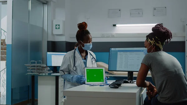 Patient und Arzt schauen auf horizontalen grünen Bildschirm auf Tablet — Stockfoto