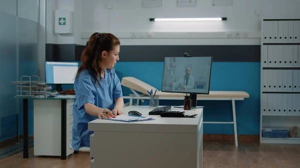 Ιατρικός βοηθός που χρησιμοποιεί βιντεοκλήση για να μιλήσει με το γιατρό στον υπολογιστή — Φωτογραφία Αρχείου