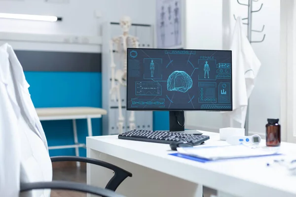Dator stående på skrivbord i tomt ljust kliniskt kontor med kroppsröntgen — Stockfoto