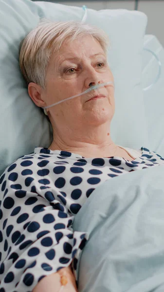鼻酸素チューブと引退した女性の肖像画ベッドに敷設 — ストック写真