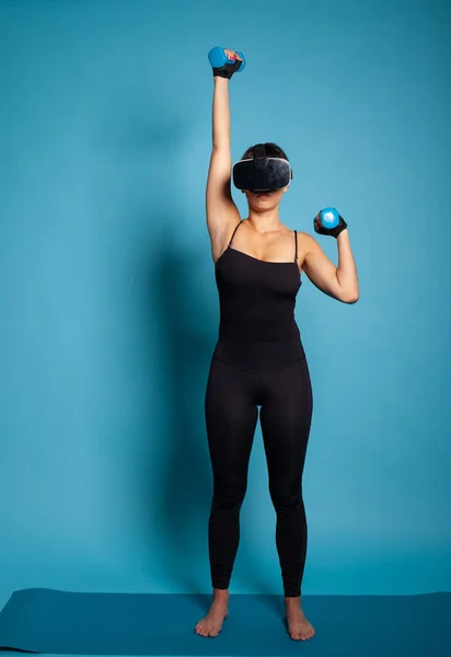 Personal trainer indossando cuffie realtà virtuale streching muscoli del braccio — Foto Stock