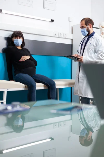 Hamileliği olan hastayı muayene etmek için dijital tablet tutan pratisyen hekim. — Stok fotoğraf