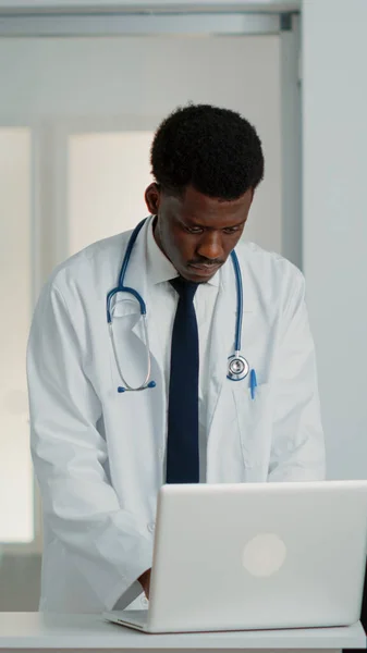 General practitioner looking at modern laptop to work — Stock Photo, Image