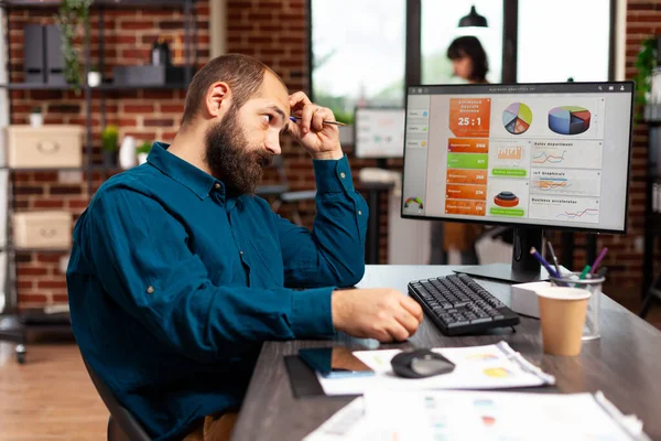 Fokuserad pensiv entreprenör sitter vid bordet tänkande på projektidéer — Stockfoto