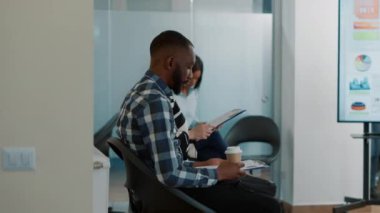 İnsan Kaynakları çalışanı Afrikalı Amerikalı bir adamı iş görüşmesine davet ediyor.